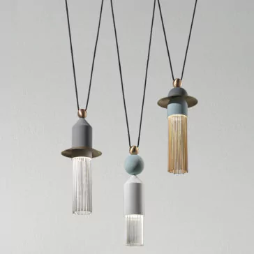 Contemporary Triple LED Pendant Light Three Contemporary Triple LED Pendant Lights hang from black cords against a gray background. Each light features a cylindrical design with a tassel-like fringe at the bottom, showcasing varying colors of gray, white, and gold accents. The lights are minimalist and stylish.