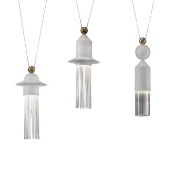 The Contemporary White LED Pendant Light Cluster hangs gracefully from the ceiling, showcasing three modern fixtures with distinctive geometric shapes and frosted glass designs. The left light features a conical shape adorned with fringe-like elements, the middle boasts a hexagonal form with similar fringe details, and the right displays a sleek cylindrical design.