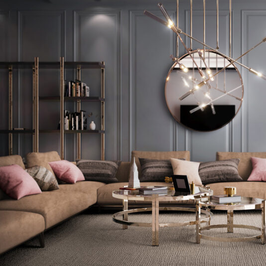 A modern living room featuring a large beige sectional sofa adorned with pink and gray pillows. In front of the sofa are two circular coffee tables with gold frames, holding books, candles, and décor. A geometric chandelier hangs above, a round mirror is on the wall, and a Large Contemporary Open Bookcase adds a stylish touch to the space.