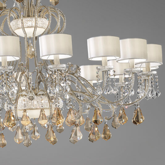 Large Crystal Chandelier With Shades The Large Crystal Chandelier With Shades boasts intricate metalwork and multiple curved arms adorned with crystal pendants. This fixture includes several cylindrical lampshades, adding an elegant touch. The varying shapes and colors of the crystals contribute a sophisticated sparkle to this exquisite piece.