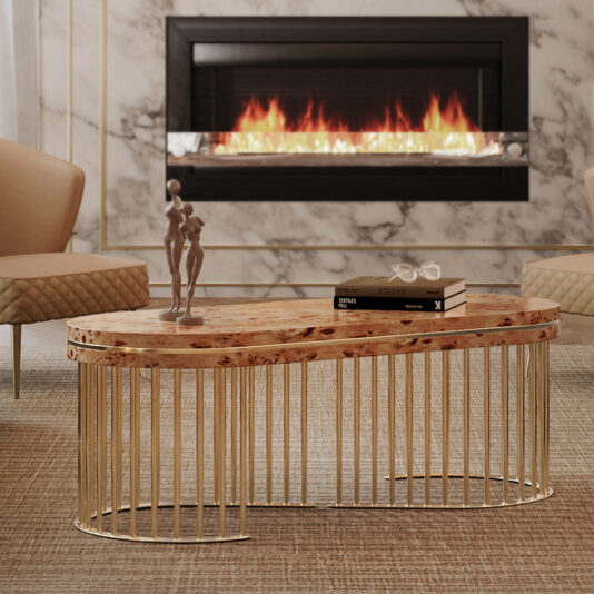 Modern Burl Veneer Coffee Table A modern living room featuring the Modern Burl Veneer Coffee Table with a golden metal base, adorned with a small sculpture and stacked books. Two beige armchairs sit on either side, and a sleek electric fireplace with a white marble surround is mounted on the wall.