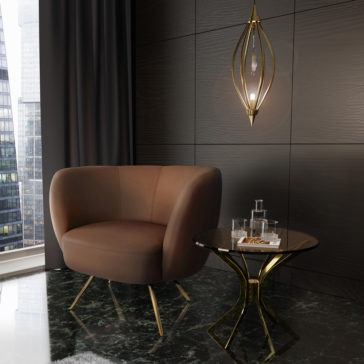 Modern Leather Tub Armchair A modern, elegantly designed room features a Modern Leather Tub Armchair in brown leather with gold legs, paired with a black marble side table. The table holds a glass water jug, two glasses, and a small plate of cookies. A gold pendant light fixture hangs on the dark paneled wall behind.