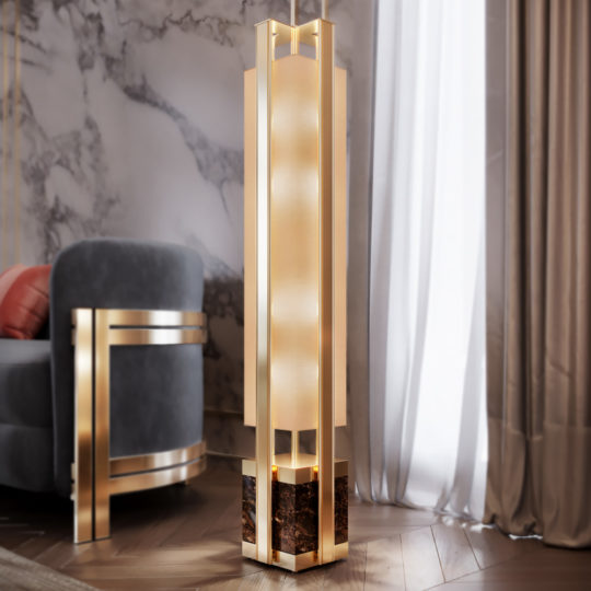 A stylish living room with marble walls and wooden flooring features the Modern Marble Floor Lamp, known for its tall, rectangular design and metal frame that emits warm light. In the background, a grey sofa with metal details complements the scene, alongside a curtain.