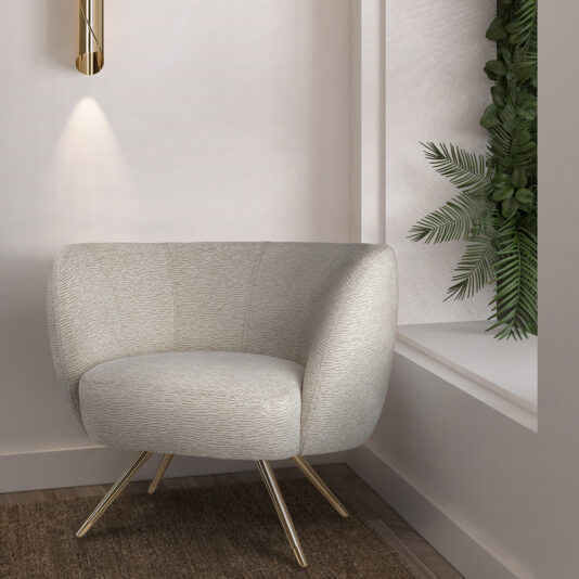 A Modern Tub Armchair with gold legs is placed in a minimalist room. A unique wall sconce with a warm light hangs above it. To the right, there is a recessed wall niche featuring green plants, adding a touch of nature to the clean, contemporary space.