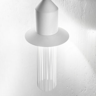 A Modern White LED Wall Light hangs from the ceiling against a white textured wall. Featuring a conical top with a wide circular brim and multiple thin, vertical elements dangling gracefully, this contemporary design creates an elegantly striking visual effect.