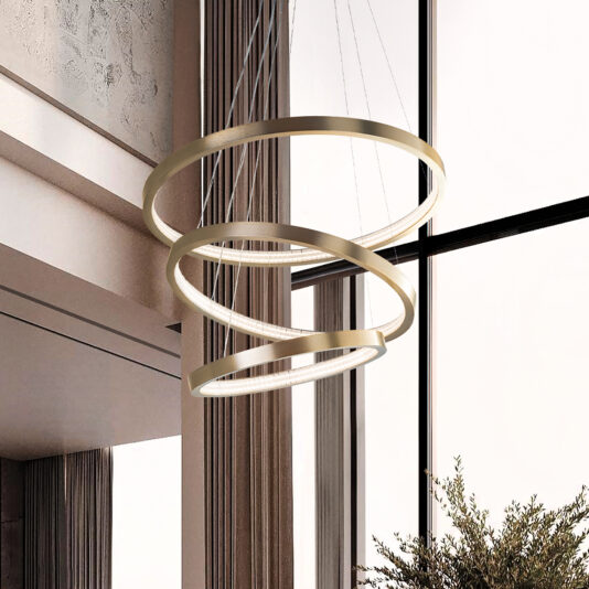 The Contemporary Round Tiered Chandelier, featuring three gold rings, elegantly hangs in a spacious room with large windows and curtains. A hint of green from a nearby plant adds to the scene.