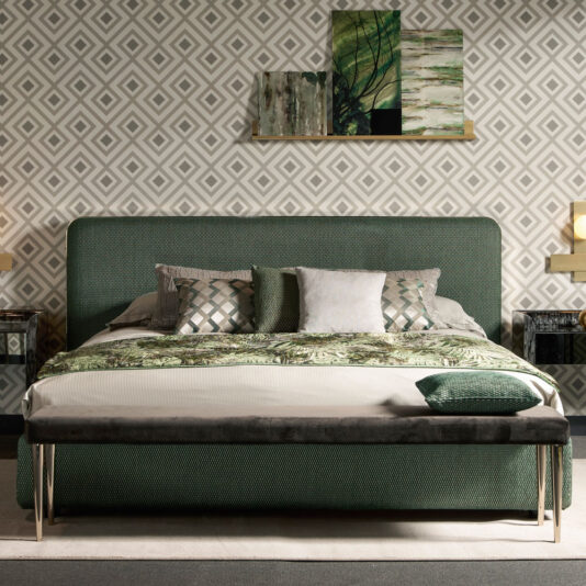 A stylish bedroom features the Contemporary Curved Upholstered Bed in green, adorned with a variety of patterned pillows. A matching bench at the foot of the bed and modern nightstands complete the look. The geometric wallpaper and abstract art pieces on the wall add a contemporary touch to the decor.