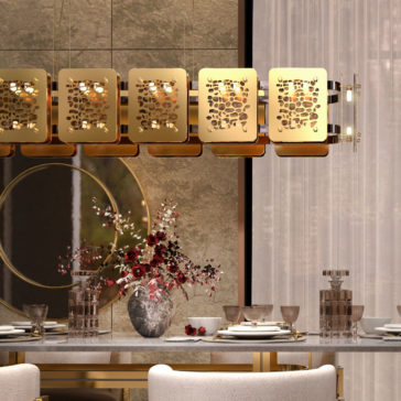 A dining room showcases an elegant setup with a Contemporary Rectangular Chandelier featuring sleek bronze panels, a large round mirror on the wall, and a table adorned with fine china, glassware, and a centerpiece of red and white flowers in a vase. Sheer curtains allow soft light to filter in.