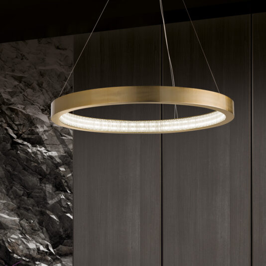 The Contemporary Round Chandelier boasts a sleek design with a warm metallic finish. It is suspended by thin wires against the backdrop of textured dark panels, casting a soft glow and adding an elegant touch to the modern setting.