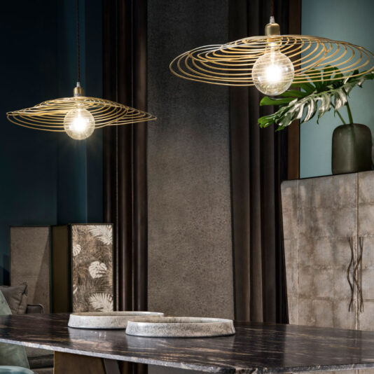 Contemporary Spiral Chandelier A modern dining room featuring two Contemporary Spiral Chandeliers hanging over a dark marble table. On the table, two decorative round stone trays are elegantly arranged. In the background, a cabinet with a textured finish and a large green plant in a gray vase add to the ambiance.