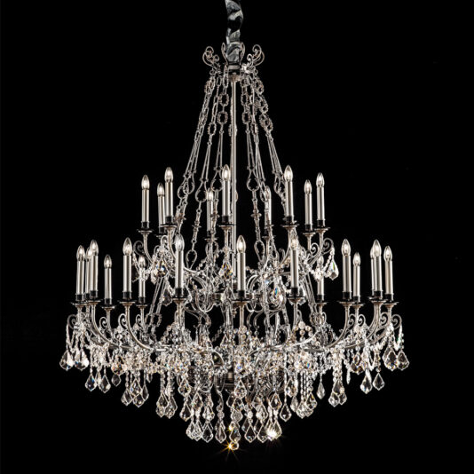 A grand and ornate Deluxe Crystal Pendant Chandelier, featuring several tiers and adorned with numerous sparkling crystal drops and candle-shaped lights, is suspended in a dramatic setting against a black background. The chandelier's intricate metalwork enhances its elegant and luxurious appearance.