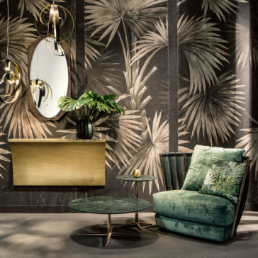 Exclusive Modern Leather Twist Armchair A stylish interior features the Exclusive Modern Leather Twist Armchair with a cushioned palm tree design, a round green coffee table, and a small side table. A brass console table with a vase of green leaves sits below an oval mirror, and the wallpaper has a prominent palm leaf pattern.