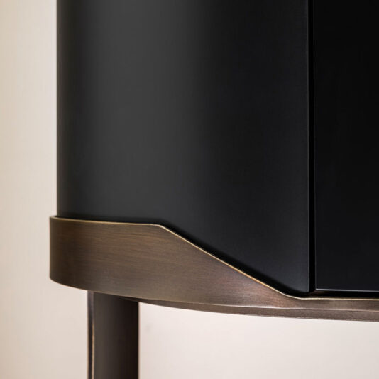 Close-up of the Large Modern Curved Cabinet in black matte with a dark wooden base. The smooth design, featuring sleek lines and a minimalist aesthetic, highlights the striking contrast between the black surface and the natural wood finish.