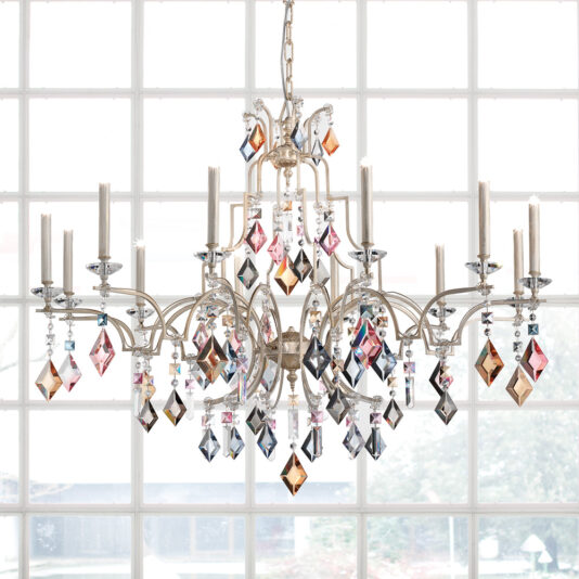 A luxurious and ornate Luxury Crystal Pendant Chandelier with multiple candle-style lights and colorful crystal pendants hangs from the ceiling in front of a large grid window, which offers a bright, airy backdrop showcasing a view of trees outside.