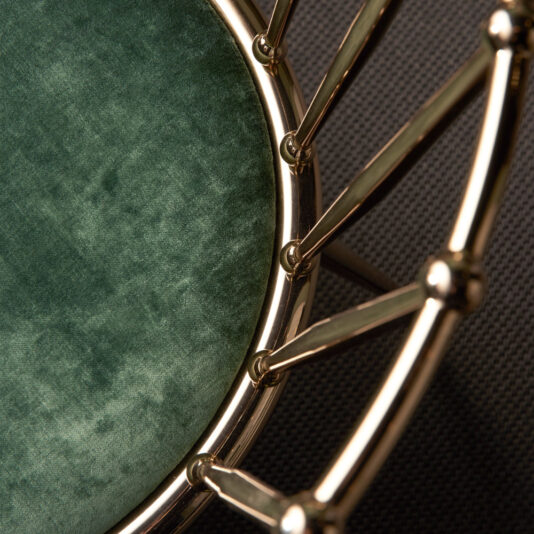 Luxury Occasional Chair A close-up shot of the Luxury Occasional Chair showcases its round, green velvet cushion and gold metallic frame. The image captures the rich velvet texture and sophisticated metallic design, emphasizing the striking contrast between the sumptuous fabric and gleaming metal.