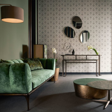 Modern Console Table Set A stylish living room showcases a green velvet sofa, a gold round coffee table, and the Modern Console Table Set adorned with vases and decor. Three round mirrors hang on a geometric patterned wall. A pendant lamp hangs from the ceiling providing warm lighting.
