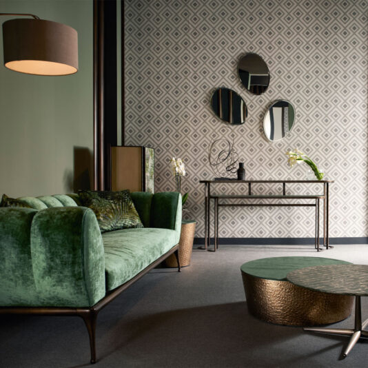 Modern Console Table Set A stylish living room showcases a green velvet sofa, a gold round coffee table, and the Modern Console Table Set adorned with vases and decor. Three round mirrors hang on a geometric patterned wall. A pendant lamp hangs from the ceiling providing warm lighting.