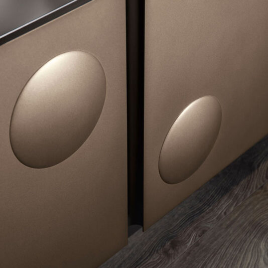 Modern Industrial 4 Door Sideboard Close-up of two brown metallic cabinet doors with large, circular recessed handles from the Modern Industrial 4 Door Sideboard. The cabinets feature a smooth, matte finish and are mounted above a dark, textured wood floor. This sleek design element adds a touch of modern industrial elegance reminiscent of high-end furniture.