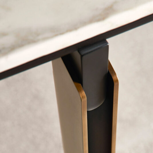 Modern Rectangular Marble Dining Table Close-up image of the modern rectangular marble dining table leg, showcasing a blend of black and gold materials that support its marble tabletop. The clean, geometric design accentuates the contrast between the sleek metallic leg and the natural stone surface.