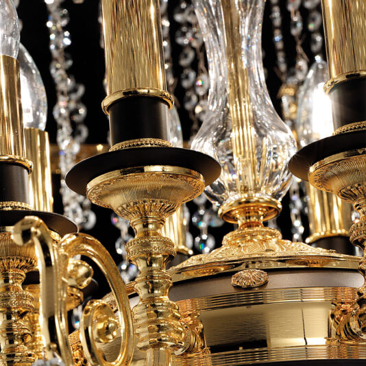 Close-up of the Opulent Crystal Pendant Chandelier, adorned with intricate golden details and multiple candle-shaped lights. Its crystal elements dangle and reflect light, creating a sparkling effect. The dark background enhances the chandelier's elegance and grandeur.