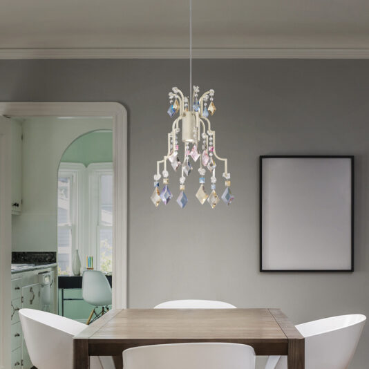 A modern dining room showcases a wooden table paired with white chairs. The space is elegantly accented by a Traditional Crystal Pendant Chandelier, adorned with colorful ornaments. An empty picture frame decorates the wall, while a doorway opens to an adjacent room themed in green.