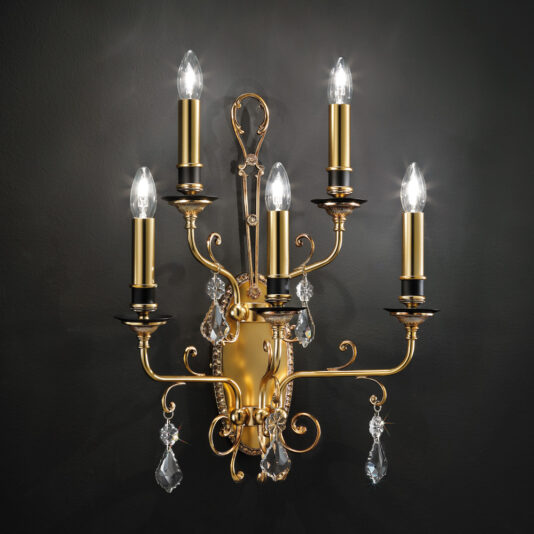 The Traditional Crystal Pendant Wall Light is a lavish gold wall sconce featuring five candle-style lights with clear, flame-shaped bulbs. The intricately designed fixture is adorned with dangling crystal ornaments and elegant curves, embodying the charm of a classic design set against a dark background.
