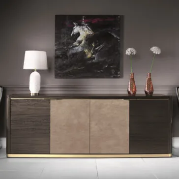 Modern Leather Front Sideboard A contemporary interior features the Modern Leather Front Sideboard, boasting a sophisticated two-tone design with dark wood and sleek leather. To the left is a white table lamp, while on the right stand two tall pink vases filled with white flowers. An abstract painting of a white horse against a dark background completes the scene above.