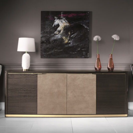 A contemporary interior features the Modern Leather Front Sideboard, boasting a sophisticated two-tone design with dark wood and sleek leather. To the left is a white table lamp, while on the right stand two tall pink vases filled with white flowers. An abstract painting of a white horse against a dark background completes the scene above.