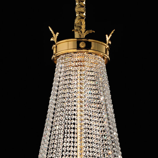 Classic Crystal Drop Empire Chandelier A luxurious Classic Crystal Drop Empire Chandelier with a gold frame and intricate crystal beading hangs against a black background. The chandelier features ornate gold decorations at the top, descending rows of sparkling crystals, creating an elegant and opulent appearance.