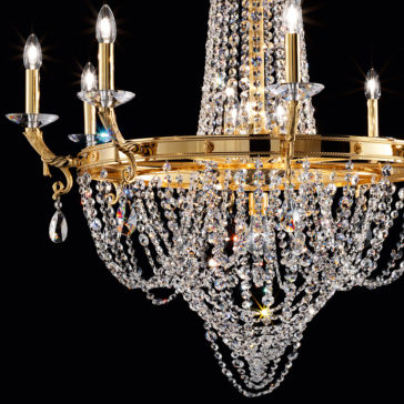 Classic Crystal Drop Chandelier The exquisite Classic Crystal Drop Chandelier features an array of sparkling crystal beads draped in elaborate strands. Its multiple candle-like bulbs emit a warm glow, accentuating the intricate design and brilliance of the crystals against a black backdrop.