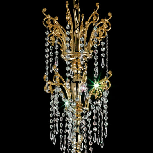 Classic Gold Plated Crystal Pendant Chandelier The Classic Gold Plated Crystal Pendant Chandelier, adorned with intricate scrollwork and cascades of hanging crystal beads and pendants, is set against a dark background, showcasing its sparkling crystals and elegant design.