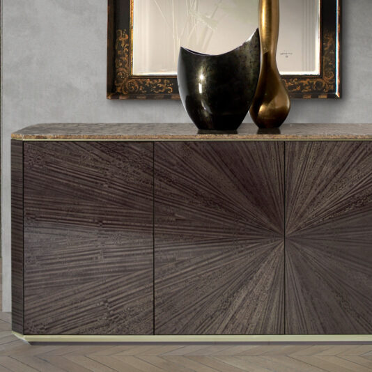 A Contemporary Grey Buffet featuring a radial veneer pattern and a marble top is set against a light gray wall. On the buffet, there are two decorative vases—one black and round, the other tall and gold. Above the buffet, a framed abstract artwork hangs on the wall.