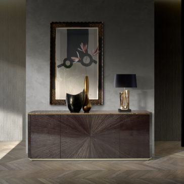 Contemporary Grey Buffet A modern, elegant room with the Contemporary Grey Buffet boasting a dark wooden sunburst pattern. Atop the buffet are two abstract vases, a metallic sculpture, and a black lampshade. Above the buffet hangs a large framed mirror reflecting contemporary art.