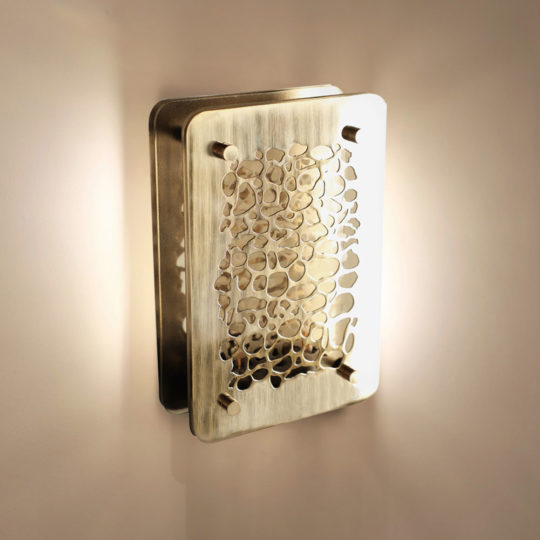 The Contemporary Wall Light boasts a sleek light golden metallic finish. Its front plate is adorned with an abstract honeycomb pattern, allowing light to gently diffuse and cast a warm, intricate glow on the surrounding wall.