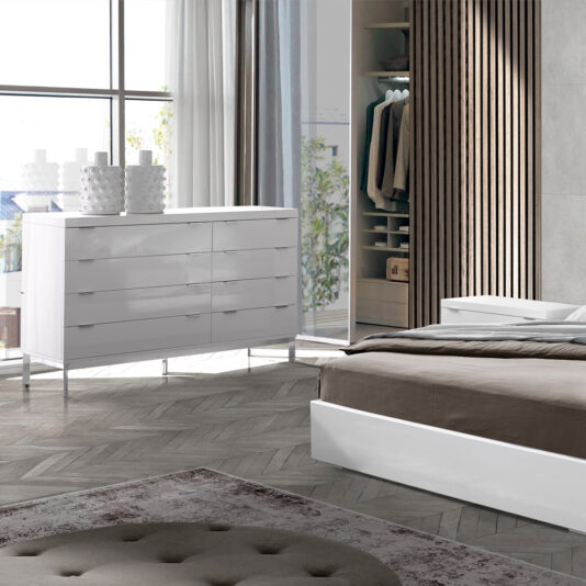 Contemporary Miami Style White Double Dresser A modern bedroom with a contemporary Miami style features a Contemporary Miami Style White Double Dresser, adorned with decorative vases by a large window. The room boasts a gray and beige color scheme with a neatly made bed, patterned area rug, and open closet. Sunlight streams through sheer curtains, illuminating the space.