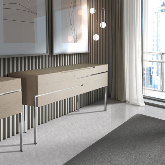 A modern room features the Elegant Sideboard With Drawers, complemented by light gray walls adorned with abstract art and a full-length window with sheer curtains. Multiple hanging bulbs form a sophisticated light fixture, illuminating a glimpse of the cityscape outside.