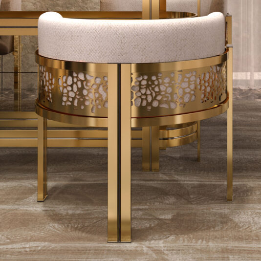 Introducing the Exclusive Curved Dining Chair, a modern masterpiece with a gold metal frame adorned with intricate cut-out designs on the sides. The seat and backrest are upholstered in light beige fabric, flawlessly complementing the wooden floor beneath, which also reflects another piece of furniture in the background.
