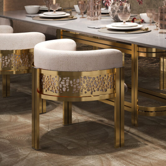 A luxurious dining setup featuring the Exclusive Curved Dining Chair, which boasts gold-accented frames and white patterned fabric, complemented by intricate lattice designs on the backrests. The table is adorned with elegant tableware, including plates, glasses, and floral arrangements. The floor is enhanced by a beautifully patterned rug.