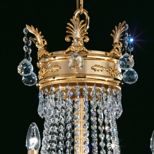 Crystal Drop Empire Chandelier The Crystal Drop Empire Chandelier boasts intricate detailing and golden accents. It features cascading strands of clear crystal beads and prisms, with teardrop-shaped crystals elegantly hanging from the upper ring, all beautifully lit to emit a sparkling glow.