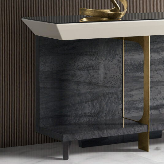 Modern Veneer Console Table The Modern Veneer Console Table, featuring a textured black surface with clean lines and a unique gold accent piece, stands against a dark, striped wall and rests on a marble floor. An elegant metallic sculptural decoration is placed on top.