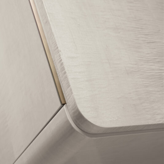 Luxury Modern Sideboard With Marble Top A close-up view of a corner of the Luxury Modern Sideboard With Marble Top, showcasing its light, neutral finish. The corner features smooth, rounded edges, and the surface has a subtle, textured wood grain pattern.