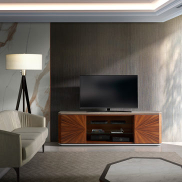 Modern living room with the Luxury Modern TV Unit on a wooden entertainment stand featuring geometric patterns. The room has elegant marble and textured walls, a beige upholstered sofa on the left, and a large floor lamp with a white shade next to the sofa.