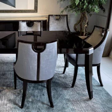 A modern dining set featuring a sleek Modern Dark Walnut Dining Table and four upholstered chairs with dark wooden frames and light gray fabric. The set is placed on a blue rug, accompanied by a stylish modern rosewood sideboard. A potted plant and framed artwork complete the sophisticated scene.
