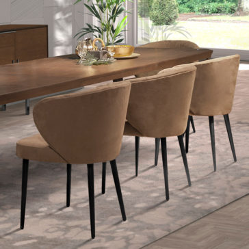 Modern Luxury Dining Set The Modern Luxury Dining Set showcases a sleek wooden table surrounded by elegant beige suede chairs with black legs. The table is beautifully decorated with a plant in a gold vase, glassware, and a small golden bowl. Natural light pours in through the windows in the background, enhancing the luxurious ambiance.