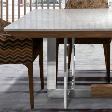 Modern Marble Top Dining Table The Modern Marble Top Dining Table, featuring a sleek metallic base with wooden accents, is paired with stylish chairs adorned in chevron-patterned fabric in earthy tones. This elegant dining set rests on a gray rug in a well-lit room, creating a contemporary and sophisticated dining space.