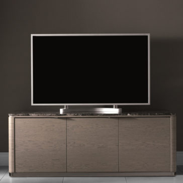 Modern Marble Top TV Unit The Modern Marble Top TV Unit showcases a sleek, flat-screen TV on its polished wooden surface. The cabinet, featuring three doors, rests elegantly against a plain, dark-colored wall. The TV screen is off and appears black in contrast to its shiny, silver frame.