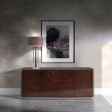 A modern, minimalistic room features the sleek Modern Rosewood Sideboard with a sunburst design under a framed monochromatic cityscape painting on a textured wall. A contemporary lamp with a beige shade is placed on the left end of the cabinet, and the floor is marble-tiled.