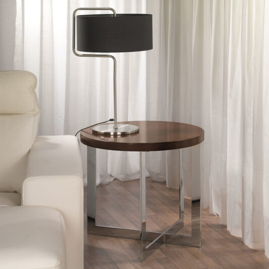 Contemporary Round Side Table A modern living room corner showcases a white leather sofa complemented by the Contemporary Round Side Table with metal legs, alongside a stylish table lamp featuring a silver base and black cylindrical shade. The setting is brightened by white curtains and highlighted by a wooden floor.