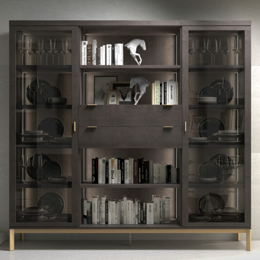 The Modern Stylish Wooden Bookcase features contemporary wooden craftsmanship with glass doors, providing ample space for various items. The shelves elegantly display books, decorative sculptures, and sets of wine glasses. Its sleek design embraces a minimalist aesthetic, complete with a centrally positioned drawer and two cabinets.