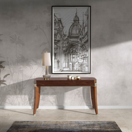 A modern interior scene featuring the Modern Walnut Console Table with gold accents. On the table sits a tall, elegant lamp and a set of three white ceramic bowls. Above the table hangs a black-and-white architectural sketch in a black frame. The wall has a subtle botanical pattern.